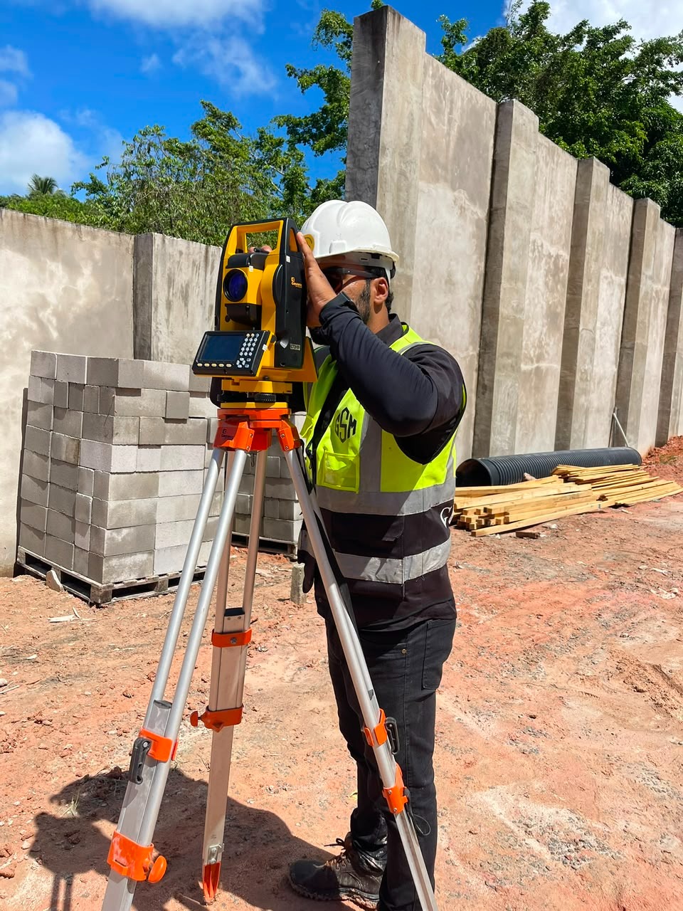 Topógrafo operando estação total em obra